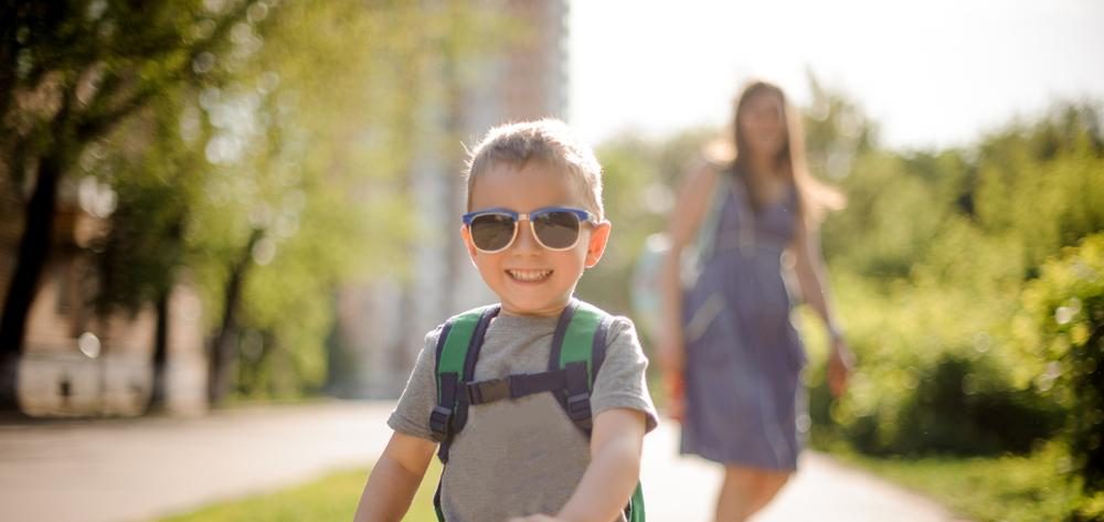 Smiling,Little,Boy,In,Sunglasses,Walking,Down,The,Street,With